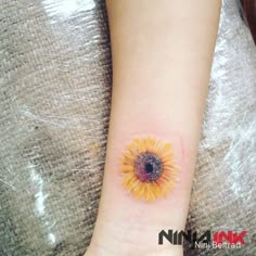 a small sunflower tattoo on the wrist