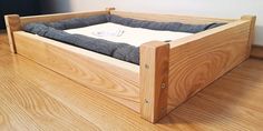 an empty wooden bed with no sheets on the top and bottom sides, sitting on a hard wood floor