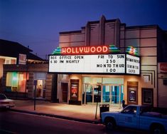 the hollywood sign is lit up at night in front of an old movie theater building