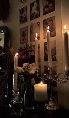 candles are lit in front of pictures on the wall