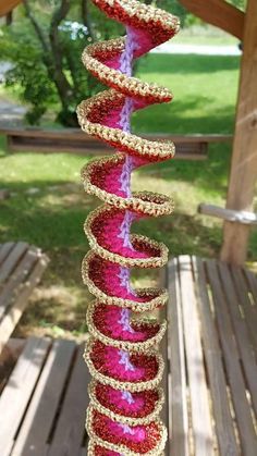 a pink and red object sitting on top of a wooden table next to a tree