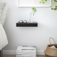 a stack of books sitting on top of a table next to a plant