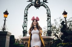 a pregnant woman is standing in front of a fountain with two heads on her head