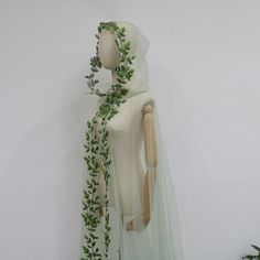 a mannequin wearing a veil with green leaves on it