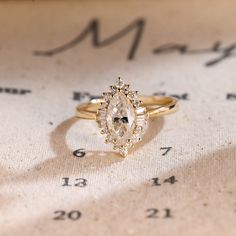 an engagement ring sitting on top of a sheet of paper