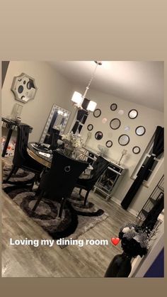 a living room filled with furniture next to a dining room table and chair covered in black chairs