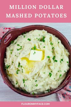 mashed potatoes with butter and parsley in a red bowl on a pink napkin