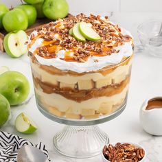 an apple dessert with whipped cream, pecans and caramel toppings on top