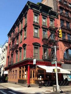 an old brick building with many windows and balconies on the top floor, in front of a traffic light