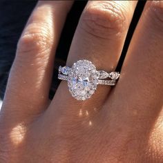 a woman's hand with a diamond ring on top of her finger and the engagement band