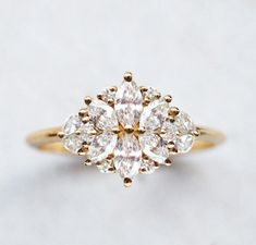 a yellow gold ring with three pear shaped diamonds