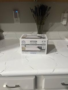 the box is sitting on top of the counter in front of the sink and faucet