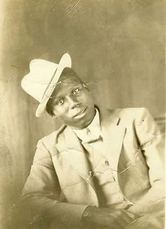 an old black and white photo of a man wearing a hat