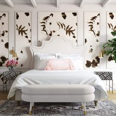 a white bed sitting in a bedroom next to a potted plant on top of a table