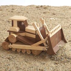 a wooden toy bulldozer sitting in the dirt