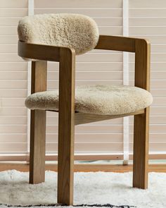 a chair with sheepskin on the seat and back rests in front of a window