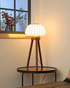 a lamp sitting on top of a table next to a window