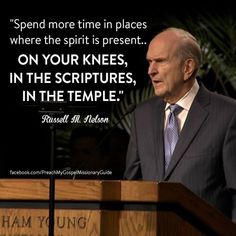 a man in a suit and tie standing at a podium with a quote on it