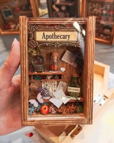 there is a miniature wooden shelf with books and other items in it that reads apothecary