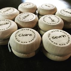 several white wooden knobs with names on them sitting on a black counter top in front of the camera