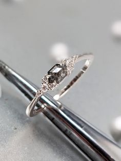 a diamond ring sitting on top of a pair of scissors