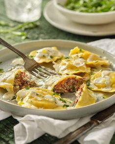 a white plate topped with ravioli and meat