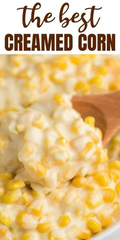 a white bowl filled with creamed corn and topped with a wooden spoon on the side