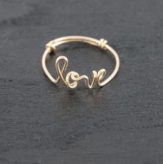 a gold ring with the word love written in cursive writing on it's side