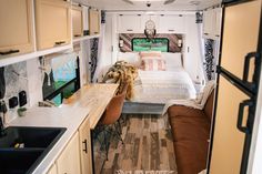 the interior of a camper with a bed and kitchen