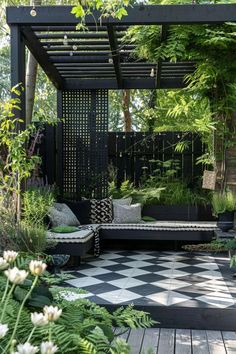 a black and white checkered floor in the middle of a garden with lots of plants