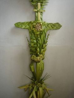 a cross made out of green leaves and flowers