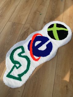 a white towel with the letters e, c, and s on it sitting on top of a wooden floor