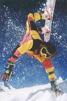 a man flying through the air while riding a snowboard on top of a snow covered slope