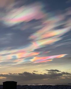 the sky is filled with colorful clouds and there are no people on the beach or in the water