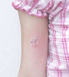 a small tattoo on the arm of a girl with a heart and an arrow in it