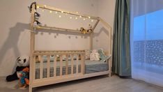 a child's room with a bed and stuffed animals on the floor next to a window