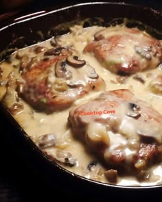 some meat covered in mushrooms and gravy in a skillet