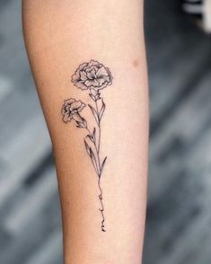 a small flower tattoo on the arm