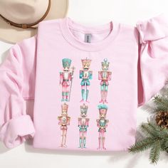 Stay cozy and festive with our Christmas Nutcracker Sweatshirt, the perfect blend of style and holiday cheer! Whether you're snuggling up by the fire or heading out for winter fun, this cute holiday crewneck adds a pop of pink color to your seasonal wardrobe. Available for women, kids, toddlers, and babies, it's a heartwarming gift that brings families together during the most magical time of the year. Spread the joy and make unforgettable memories this holiday season with this comfy, stylish wi Soldier Christmas, Holiday Crewneck, Pink Nutcracker, Christmas Soldiers, Seasonal Wardrobe, Nutcracker Soldier, Matching Sweaters, Winter Pullover, Sweatshirt Cute