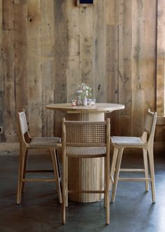 two chairs and a table in front of a wooden wall