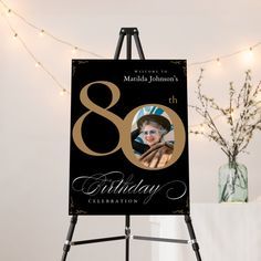 a black and gold 80th birthday card on an easel