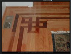 a close up of a wooden floor with a rug on the ground and an air vent