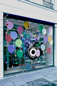 a store front with balloons in the window