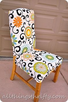 an upholstered chair sitting in front of a garage door with a flower pattern on it