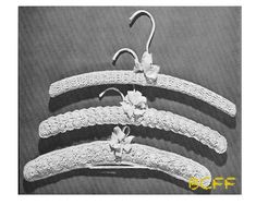 three white crochet hangers with flowers on each one and an ear hook