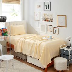 a bedroom with white walls and pictures on the wall