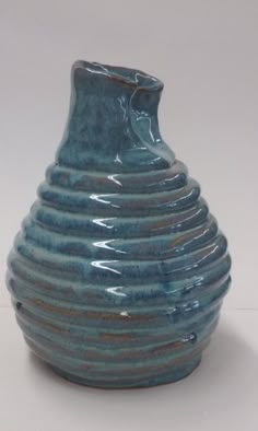 a blue vase sitting on top of a white table