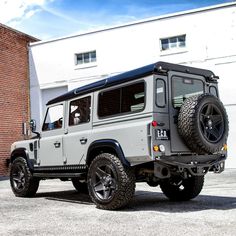 a white and black jeep parked in front of a building