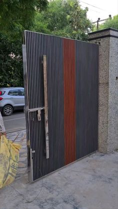 a man walking past a tall metal gate