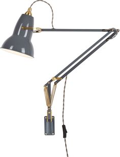 a black and gold desk lamp on a white background, with the light turned off